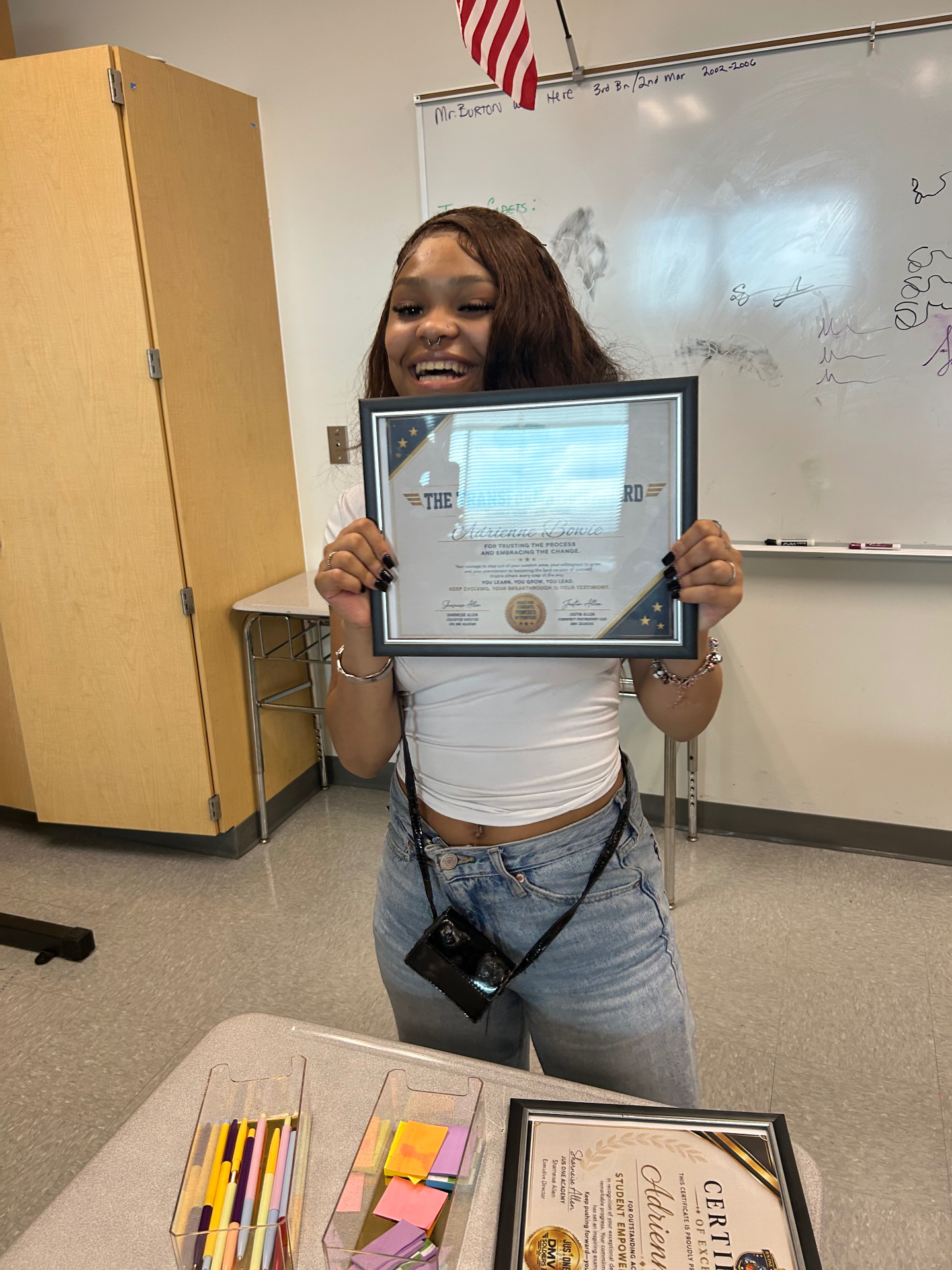 Student smiling after receiving a certificate during a Jus One Academy session